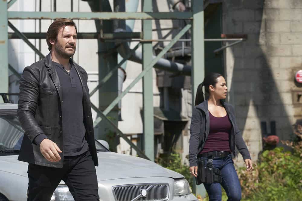 TAKEN -- "Charm School" Episode 206 -- Pictured: (l-r) Clive Standen as Bryan Mills, Jessica Camacho as Santana -- (Photo by: Steve Wilkie/NBC)