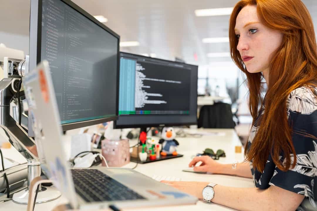 girl working with two monitors at desk