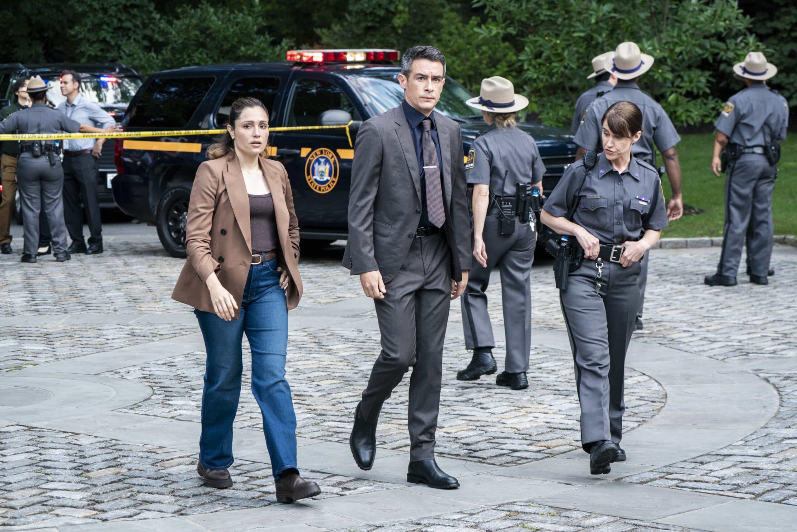 “Manifest” – Following a failed assassination attempt on a U.S. senator, OA and Maggie are tasked with escorting her back to Washington, D.C. on a flight that becomes more perilous than imagined, on FBI, Monday, Nov. 3 (9:00-10:00 PM, ET/PT) on the CBS Television Network, and streaming on Paramount+ (live and on-demand for Paramount+ Premium plan subscribers, or on-demand for Paramount+ Essential subscribers the day after the episode airs).  Pictured (L-R): Juliana Aidén Martinez as Eva Ramos, John Boyd as Special Agent Stuart Scola, and Joanne Ryan as Police Chief Mulroney. Photo: Bennett Raglin/CBS ©2025 CBS Broadcasting, Inc. All Rights Reserved.