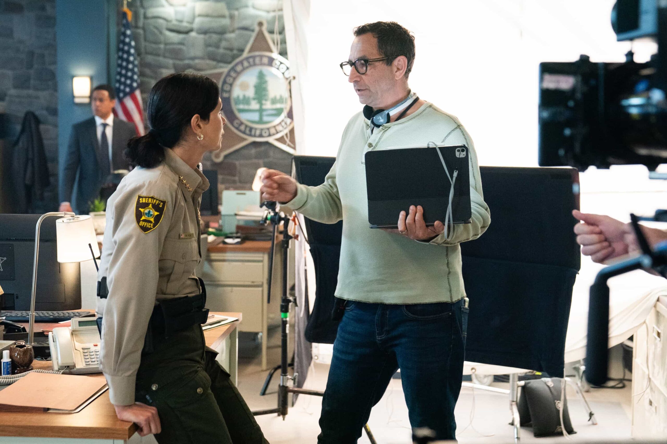 “Out of Office” – When Skye becomes the prime suspect in a murder case, Mickey is forced to step down amid the investigation and launch her own off-the-books search for the truth. As tensions rise and family loyalties are tested, Mickey risks everything to try and clear her daughter’s name, on SHERIFF COUNTRY, Friday, Nov. 7 (8:00-9:00 PM, ET/PT) on the CBS Television Network, and streaming on Paramount+ (live and on-demand for Paramount+ Premium plan subscribers, or on-demand for Paramount+ Essential subscribers the day after the episode airs)*. Pictured: Morena Baccarin and Director Ed Ornelas. Photo: Robin Cymbaly/CBS ©2025 CBS Broadcasting, Inc. All Rights Reserved.