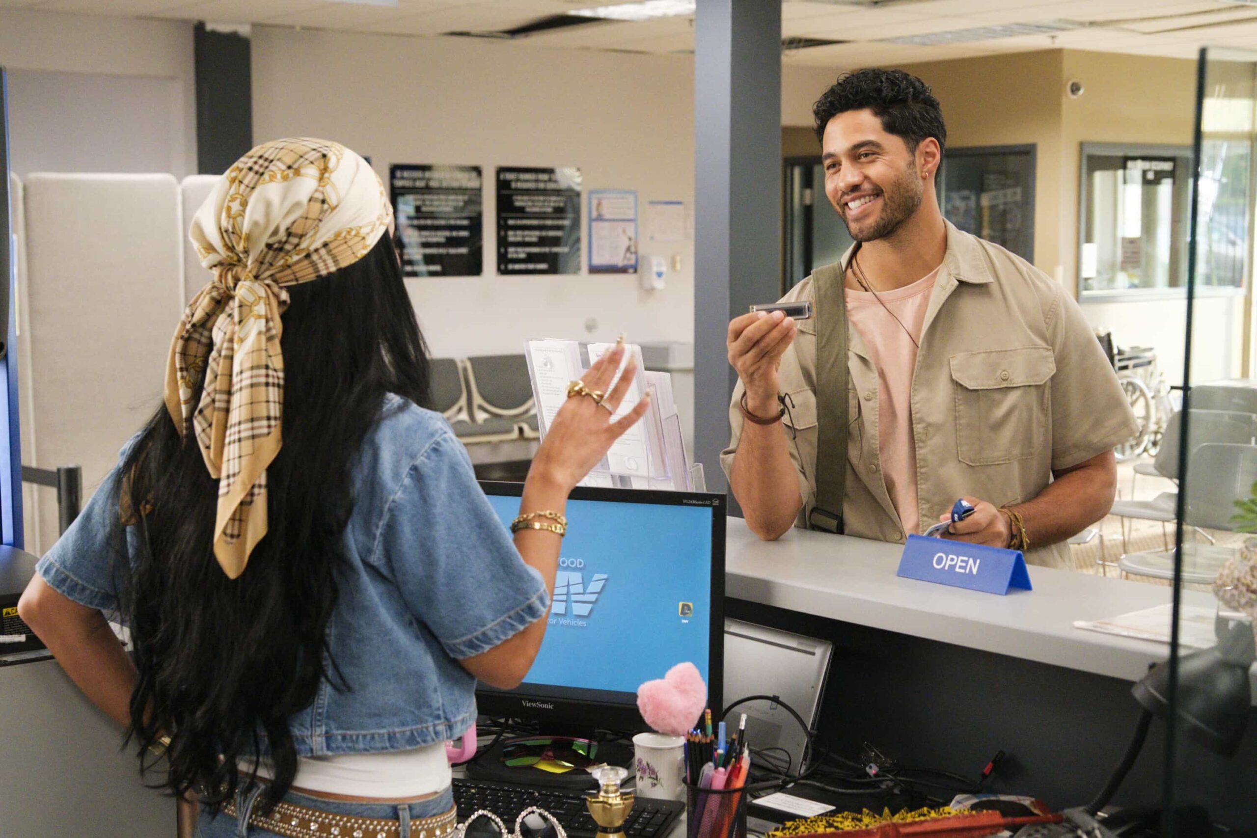 “Stick Shift” – When Ceci accuses Colette of only being kind for the credit, Colette anonymously gives Noa the perfect gift, on DMV, Monday, Nov. 10 (8:30-9:00 PM, ET/PT) on the CBS Television Network, and streaming on Paramount+ (live and on-demand for Paramount+ Premium plan subscribers, or on-demand for Paramount+ Essential subscribers the day after the episode airs)*. Pictured L to R:  Gigi Zumbado as Ceci and Alex Tarrant as Noa. Photo: Bertrand Calmeau/CBS ©2025 CBS Broadcasting, Inc. All Rights Reserved.