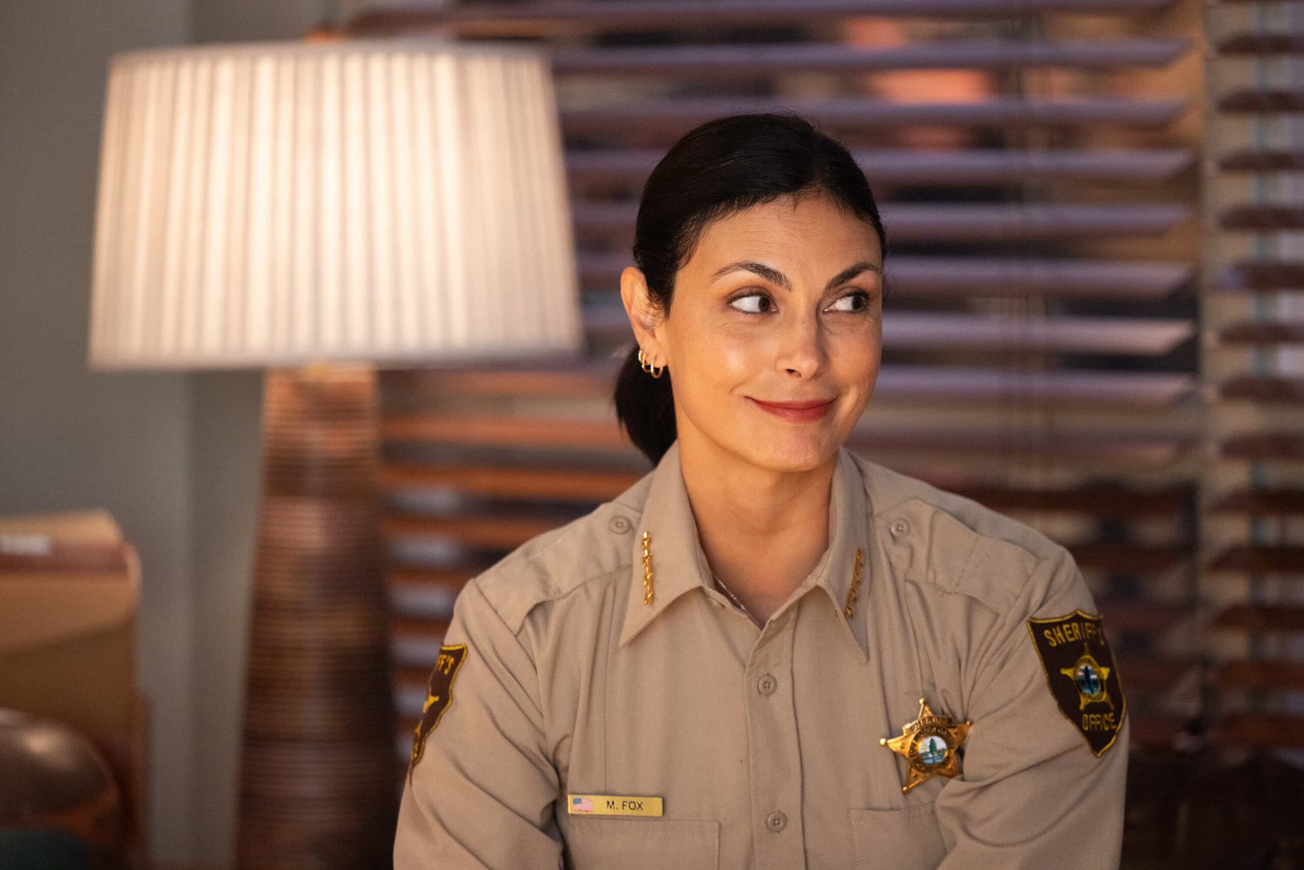 “Death & Taxes” – As cannabis growers in Edgewater scramble to pay their taxes in cash, a violent robbery leaves a man in critical condition and exposes the vulnerability of the legal cannabis trade. Meanwhile, Mickey navigates a tense meal with her stepsister, Sharon (FIRE COUNTRY), on SHERIFF COUNTRY, Friday, Dec. 12 (8:00-9:00 PM, ET/PT) on the CBS Television Network, and streaming on Paramount+ (live and on-demand for Paramount+ Premium plan subscribers, or on-demand for Paramount+ Essential subscribers the day after the episode airs)*. Pictured: Morena Baccarin as Sheriff Mickey Fox. Photo: Darren Goldstein/CBS ©2025 CBS Broadcasting, Inc. All Rights Reserved.