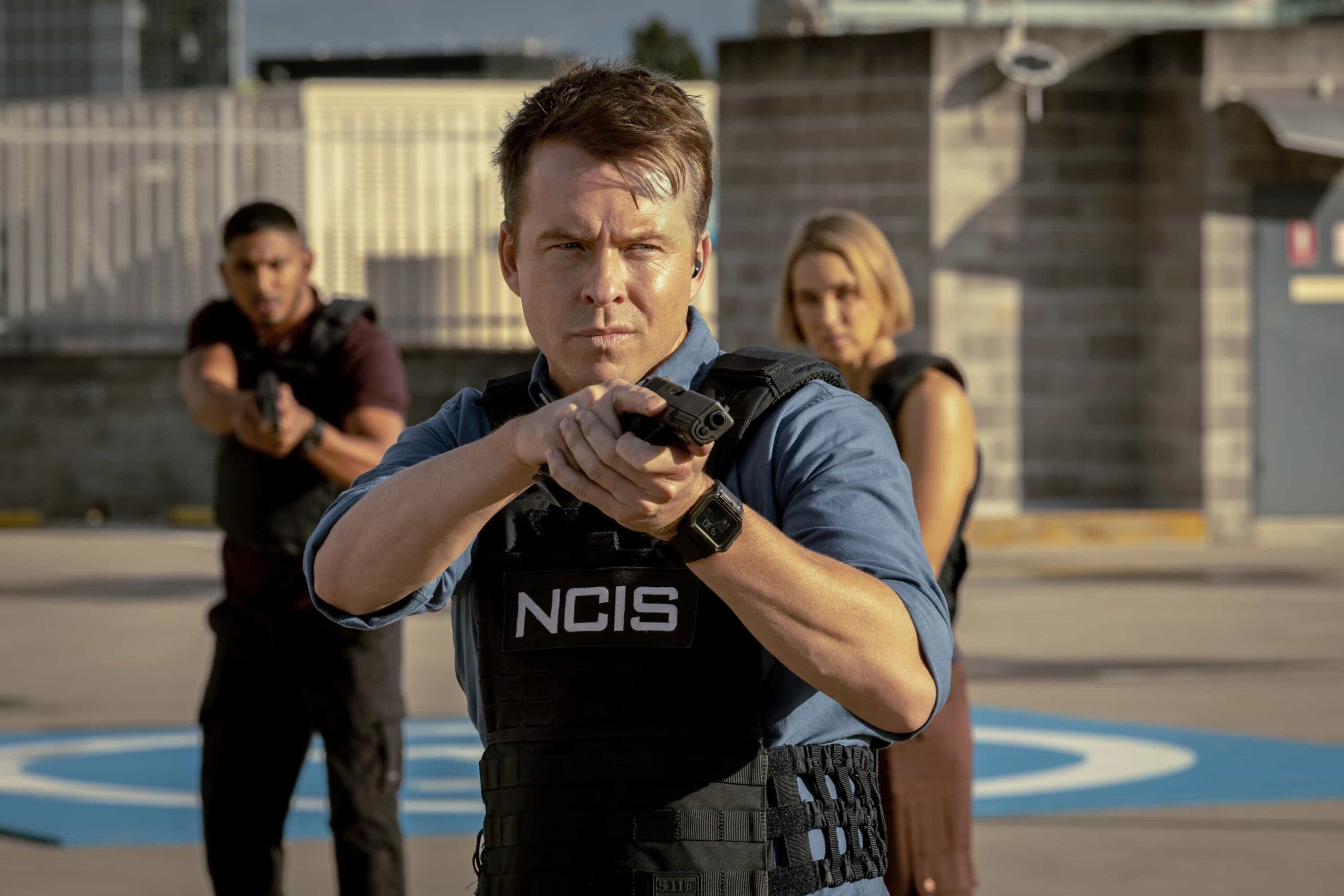 “Sucker Punch” – Confronted with Australia’s first case of Ebola, the team races to uncover how patient zero, a U.S. Navy scientist, contracted the deadly virus, only to have their search for answers complicated by a top-secret military research agency as two of their own fight for their lives, on NCIS: SYDNEY, Tuesday, Nov. 18 (10:00-11:00 PM, ET/PT) on the CBS Television Network, and streaming on Paramount+ (live and on demand for Paramount+ Premium plan subscribers, or on demand for Paramount+ Essential subscribers the day after the episode airs)*. L-R: Sean Sagar as NCIS Special Agent DeShawn Jackson, Todd Lasance as AFP Liaison Officer Sergeant Jim \'JD\' Dempsey and Tuuli Narkle as AFP Liaison Officer Constable Evie Cooper in NCIS: Sydney episode 6, season 3 streaming on Paramount+, 2025. Photo Credit:  Daniel Asher Smith/Paramount+   © TM & © 2025 CBS Studios Inc. NCIS: Sydney and related marks and logos  are trademarks of CBS Studios Inc. All Rights Reserved.