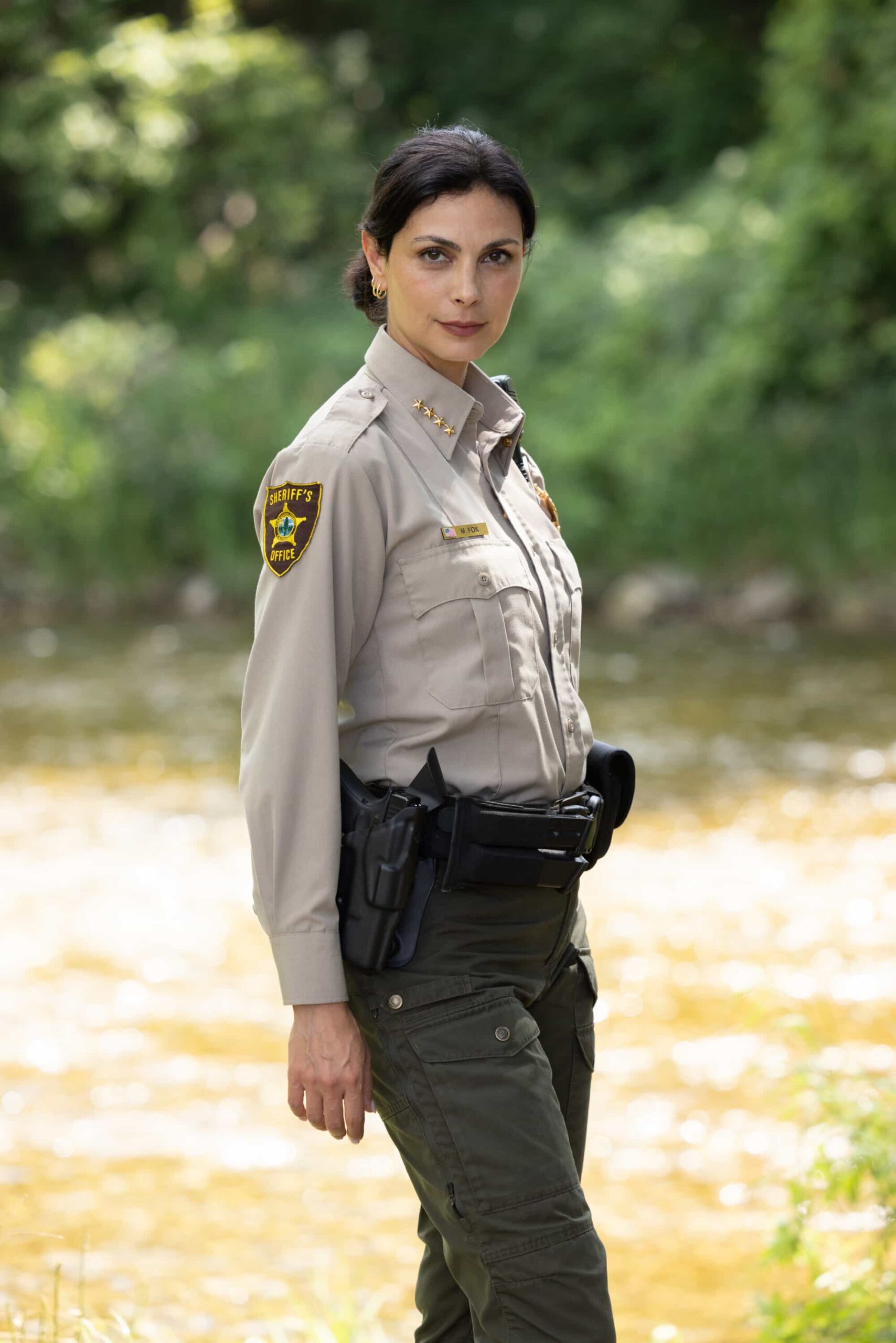 Sheriff Country Season 1 Episode 6 “Exit Interview” – When a body is discovered along the Eel River, Sheriff Mickey Fox and her team launch a homicide investigation that rattles the heart of Edgewater. Meanwhile, Wes risks everything to uncover the truth about the murder, on SHERIFF COUNTRY, Friday, Nov. 21 (8:00-9:00 PM, ET/PT) on the CBS Television Network, and streaming on Paramount+ (live and on-demand for Paramount+ Premium plan subscribers, or on-demand for Paramount+ Essential subscribers the day after the episode airs)*.  Pictured: Morena Baccarin. Photo: Darren Goldstein/CBS ©2025 CBS Broadcasting, Inc. All Rights Reserved.