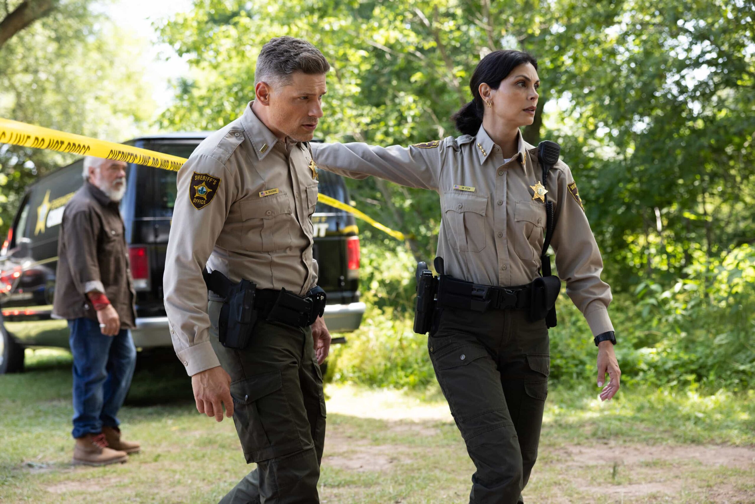Sheriff Country Season 1 Episode 6 “Exit Interview” – When a body is discovered along the Eel River, Sheriff Mickey Fox and her team launch a homicide investigation that rattles the heart of Edgewater. Meanwhile, Wes risks everything to uncover the truth about the murder, on SHERIFF COUNTRY, Friday, Nov. 21 (8:00-9:00 PM, ET/PT) on the CBS Television Network, and streaming on Paramount+ (live and on-demand for Paramount+ Premium plan subscribers, or on-demand for Paramount+ Essential subscribers the day after the episode airs)*.  Pictured: Matt Lauria as Boone and Morena Baccarin as Sheriff Mickey Fox. Photo: Darren Goldstein/CBS ©2025 CBS Broadcasting, Inc. All Rights Reserved.