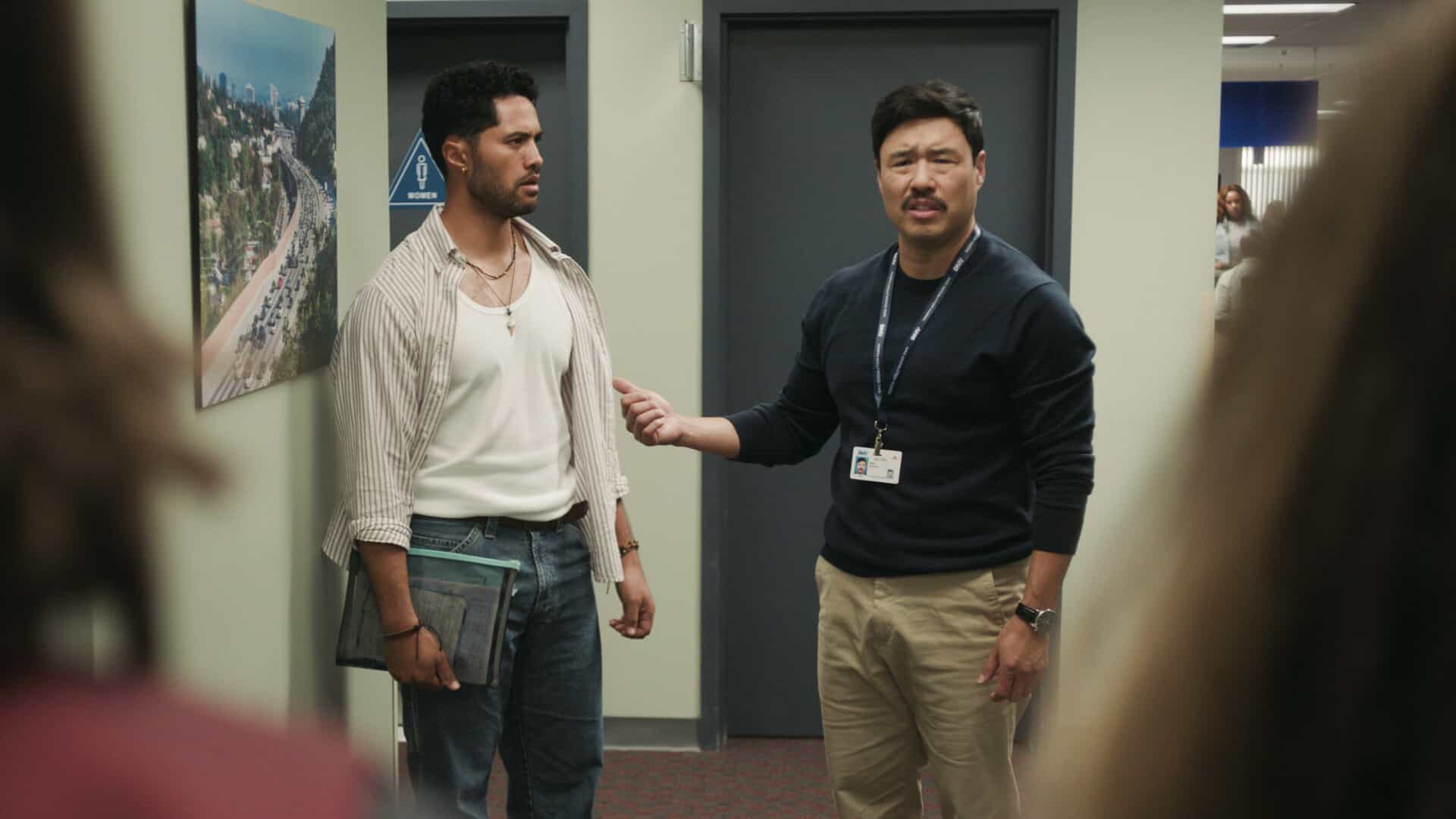 DMV Season 1 Episode 7  “There Is No I in DMV” – Barb takes the team on a field trip to the rival North Hollywood branch to learn the secrets of their success. She begins to doubt herself after meeting their charismatic manager, Beau (Randall Park). Meanwhile, Gregg and Vic get in Colette’s head that Noa prefers risk-takers, on DMV, Monday, Nov. 24 (9:30-10:00 PM, ET/PT) on the CBS Television Network, and streaming on Paramount+ (live and on-demand for Paramount+ Premium plan subscribers, or on-demand for Paramount+ Essential subscribers the day after the episode airs)*. Pictured L to R: Alex Tarrant as Noa and Randall Park as Beau Young. Photo: CBS ©2025 CBS Broadcasting, Inc. All Rights Reserved. Highest quality screengrab available.