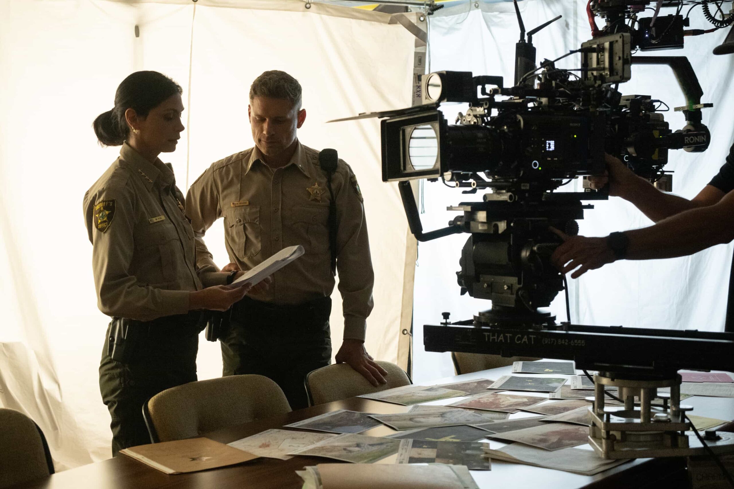 “Glory Days” BTS – While investigating a brutal assault at Edgewater High, Sheriff Mickey Fox uncovers a disturbing web of secrets, lies and abuse of power at the school, on SHERIFF COUNTRY, Friday, Dec. 5 (8:00-9:00 PM, ET/PT) on the CBS Television Network, and streaming on Paramount+ (live and on-demand for Paramount+ Premium plan subscribers, or on-demand for Paramount+ Essential subscribers the day after the episode airs)*. Pictured: Morena Baccarin and Matt Lauria. Photo: Christos Kalohoridis/CBS ©2025 CBS Broadcasting, Inc. All Rights Reserved.