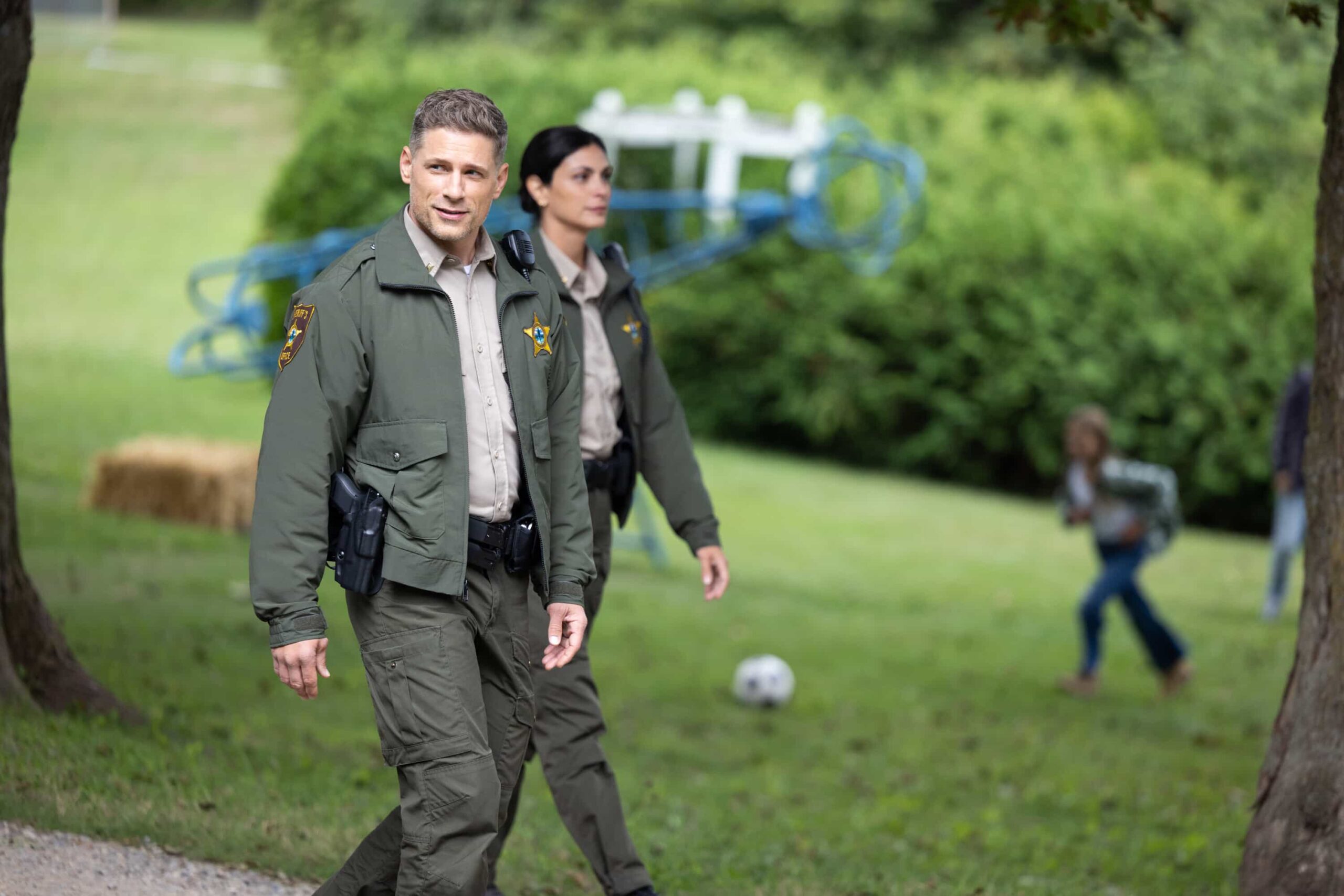 Sheriff Country Season 1 Episode 9 “Crucible, Part 1” – After a father and son flee a secluded ranch run by one of Edgewater’s most power families, Mickey investigates disturbing allegations of abuse and uncovers dangerous secrets, which leads to a tense standoff and confrontation, on SHERIFF COUNTRY, Friday, Dec. 19 (8:00-9:00 PM, ET/PT). Pictured: Matt Lauria as Boone and Morena Baccarin as Sheriff Mickey Fox. Photo: Darren Goldstein/CBS ©2025 CBS Broadcasting, Inc. All Rights Reserved.