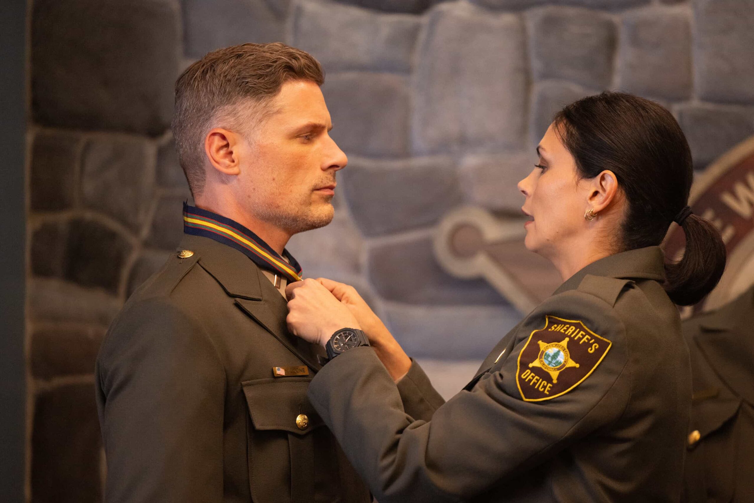 Sheriff Country Season 1 Episode 11 “The Aftermath” – When a courthouse security test ends in a shocking murder, Sheriff Mickey Fox uncovers a dangerous conspiracy reaching deep into Edgewater’s justice system.Pictured: Matt Lauria as Boone and Morena Baccarin as Sheriff Mickey Fox. Photo: Darren Goldstein/CBS ©2025 CBS Broadcasting, Inc. All Rights Reserved.