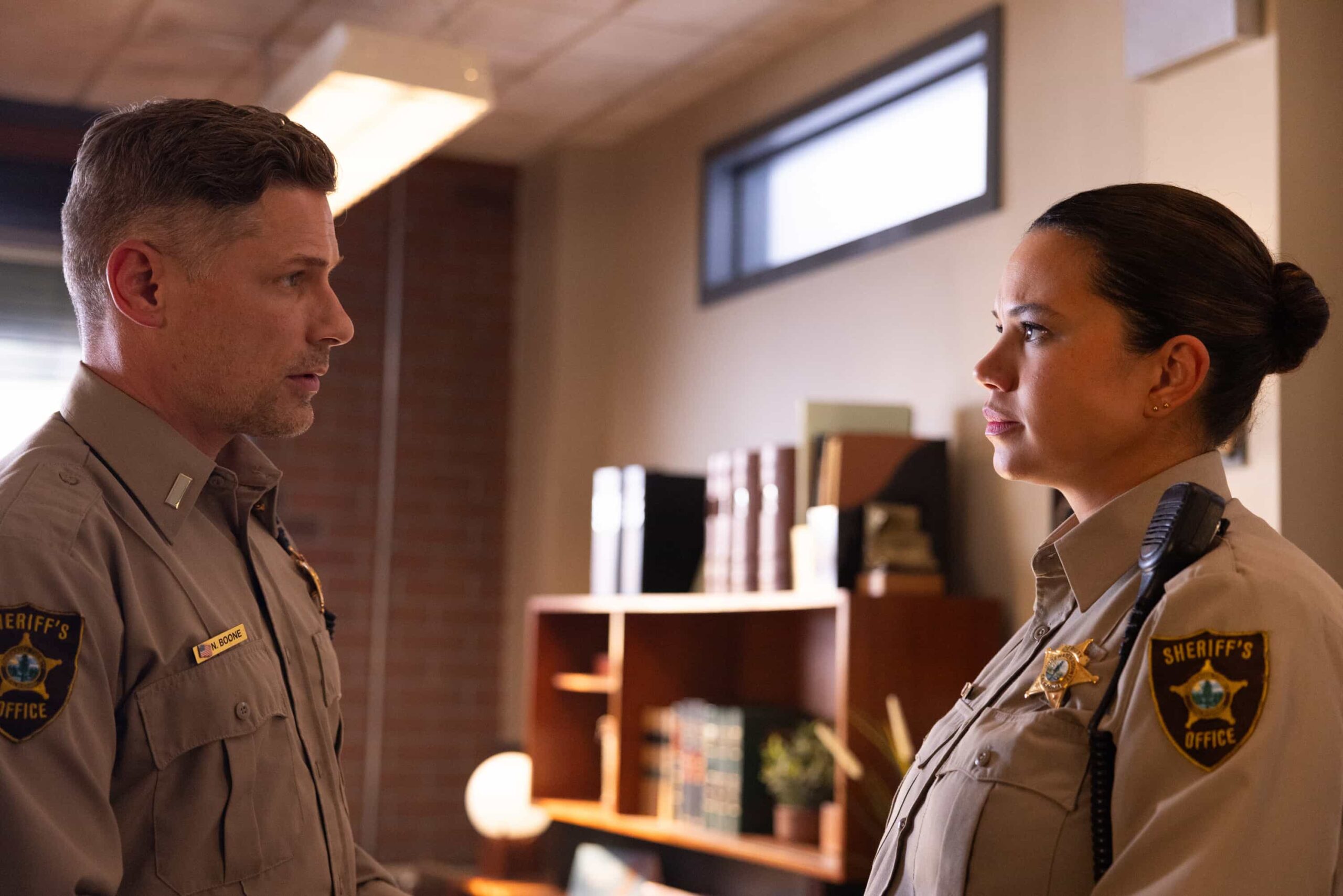 “The Aftermath” – When a courthouse security test ends in a shocking murder, Sheriff Mickey Fox uncovers a dangerous conspiracy reaching deep into Edgewater’s justice system.Pictured: Matt Lauria as Boone and Michele Weaver as Cassidy Campbell. Photo: Darren Goldstein/CBS ©2025 CBS Broadcasting, Inc. All Rights Reserved.