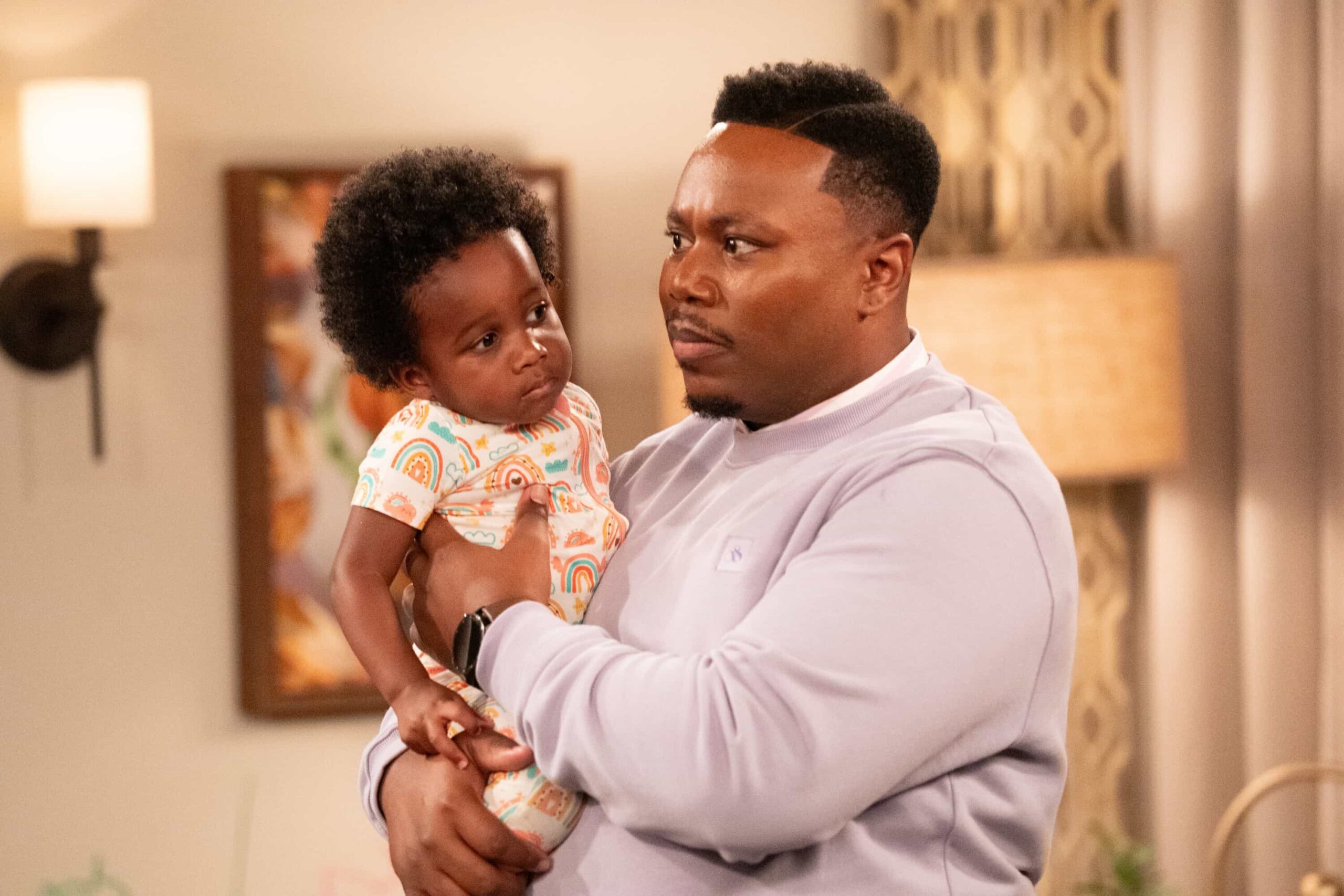 The Neighborhood Season 8 Episode 11 “Welcome to the Baby Proofing” – While Marty heads to San Diego for a tech convention and Courtney is away for the weekend, Tina’s insistence on babysitting Daphne sparks a baby-proofing fiasco that leaves Calvin and Dave unexpectedly locked inside the bathroom, on THE NEIGHBORHOOD, Pictured: Ky’elle Delery and Ky’aire Delery as Baby Daphne and  Marcel Spears as Marty. Photo: Monty Brinton/CBS ©2025 CBS Broadcasting, Inc. All Rights Reserved.