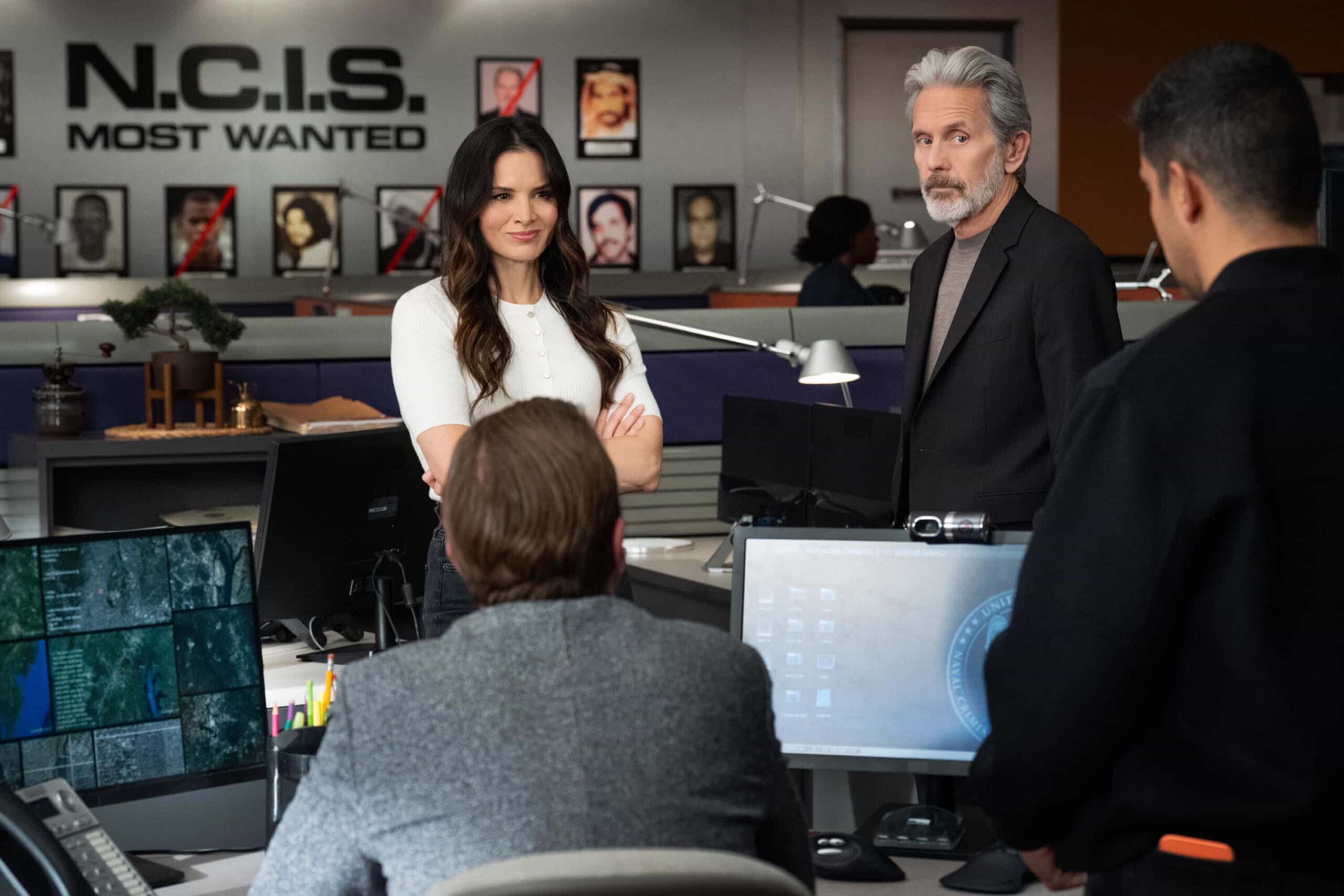 NCIS Season 23 Episode 11 Photo “Army of One” – When a desperate man barricades himself inside an ammo warehouse, Knight is the only negotiator he’ll talk to, claiming she once saved him before. As explosives tick and trust frays, Knight clashes with the CID officer running the standoff, each convinced theirs is the only way out, on the CBS Original series NCIS, Tuesday, March 10 (8:00-9:00 PM, ET/PT) on the CBS Television Network, and streaming on Paramount+    Pictured (L-R):Katrina Law as Special Agent Jessica Knight,  Gary Cole as Special Agent Alden Parker, Wilmer Valderrama as Special Agent Nicholas “Nick” Torres and  Sean Murray as Special Agent Timothy McGee  Photo: Robert Voets/CBS ©2025 CBS Broadcasting, Inc. All Rights Reserved.