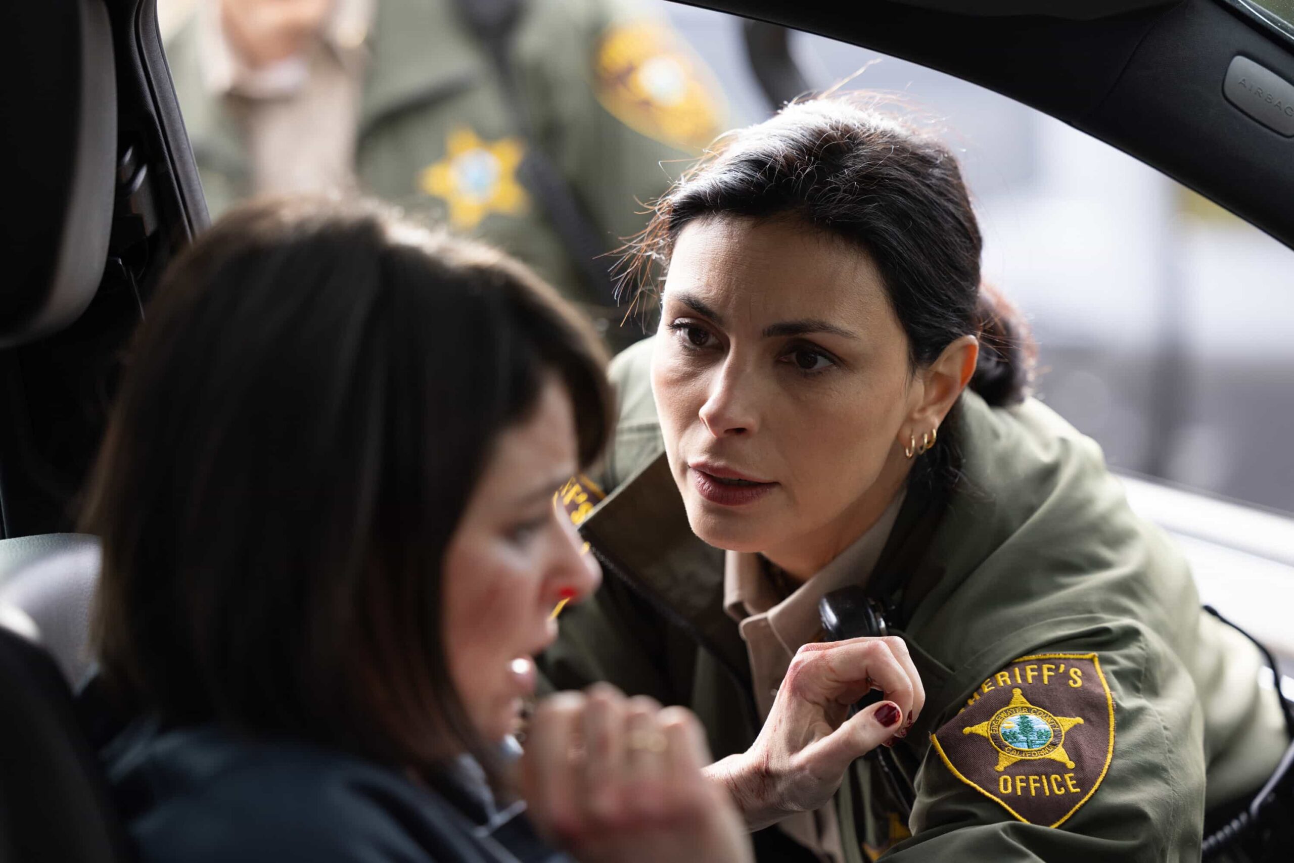 Sheriff Country Season 1 Episode 12 Photo "Plus One" -- Coverage of the CBS Original Series SHERIFF COUNTRY, scheduled to air on the CBS Television Network.  Pictured: MacKenzie Meehan as Carrie Carson and Morena Baccarin as Sheriff Mickey Fox. Photo: Darren Goldstein/CBS ©2025 CBS Broadcasting, Inc. All Rights Reserved.