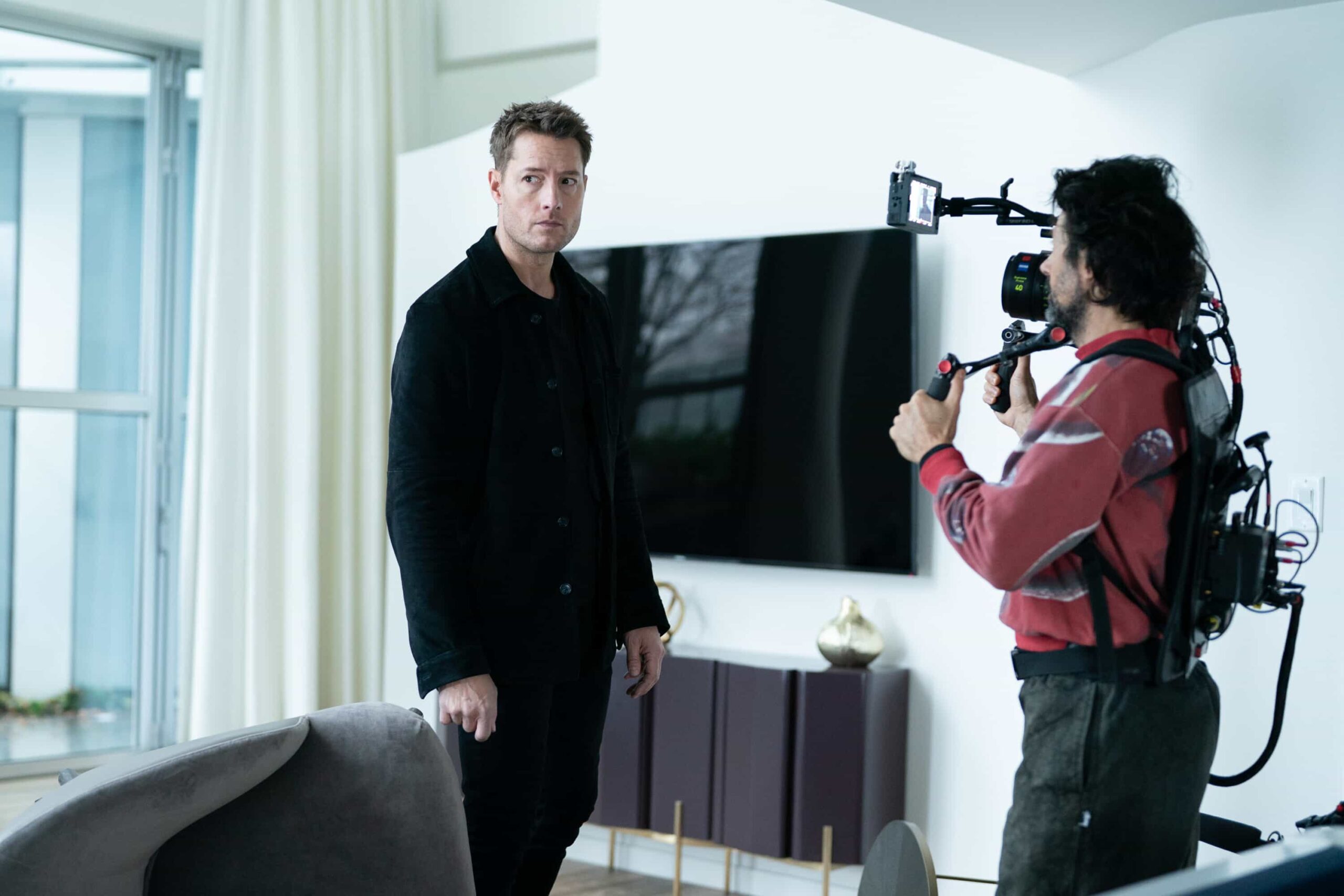 BTS “Breakaway” – After Baxter, a veteran stuntman, disappears following a risky stunt, his girlfriend, Laura, calls Colter to investigate a B-movie set, uncovering shady producers and a trail that leads into a dangerous underground world. Pictured: Justin Hartley and A-Cam Operator Vlad Horodinca. Photo: Darko Sikman/CBS ©2025 CBS Broadcasting, Inc. All Rights Reserved.