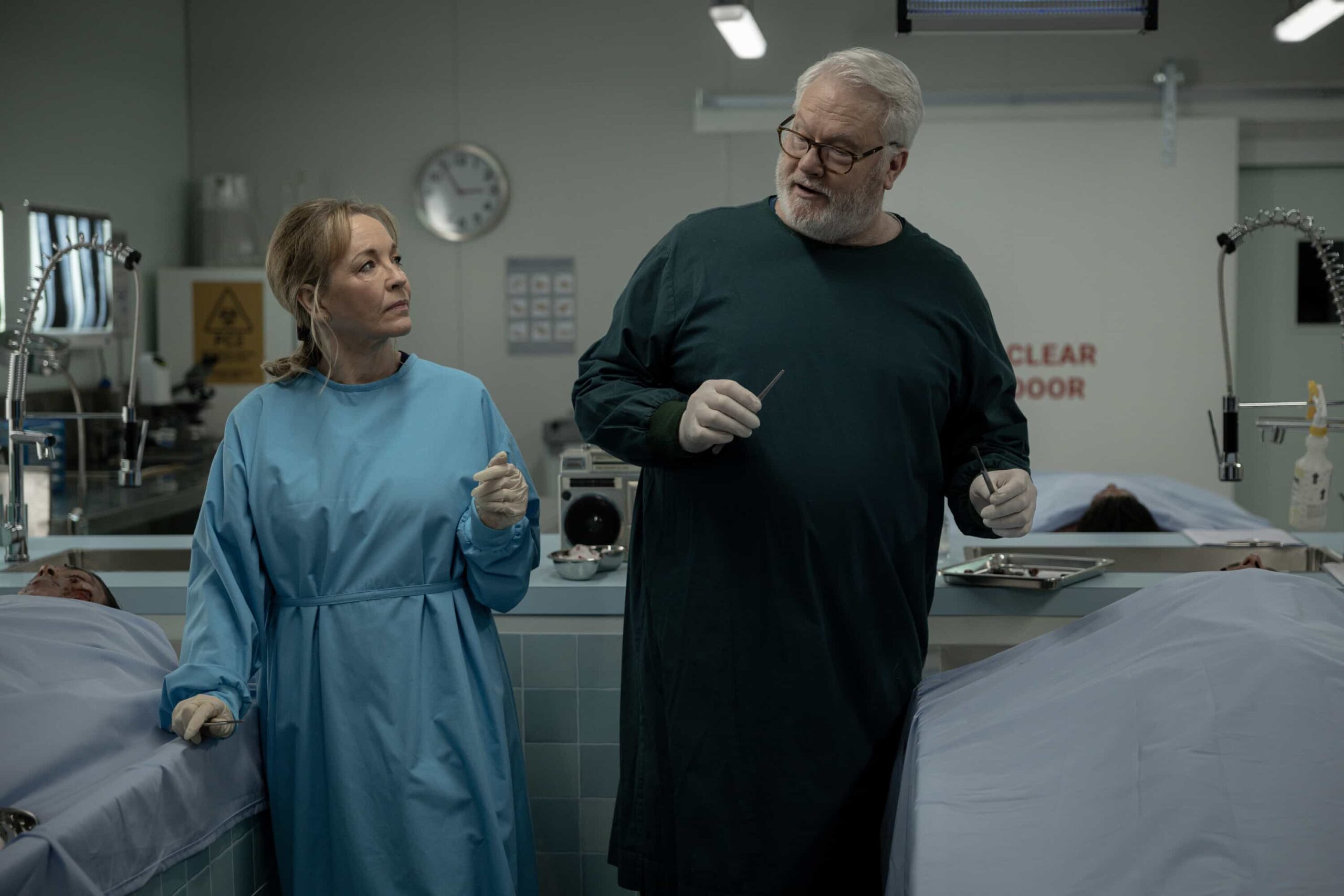 Rebecca Gibney as Nia Williams and William McInnes as Forensic Pathologist Dr. Roy Penrose in NCIS: Sydney episode 12, season 3 streaming on Paramount+, 2026. Photo Credit:  Daniel Asher Smith/Paramount+