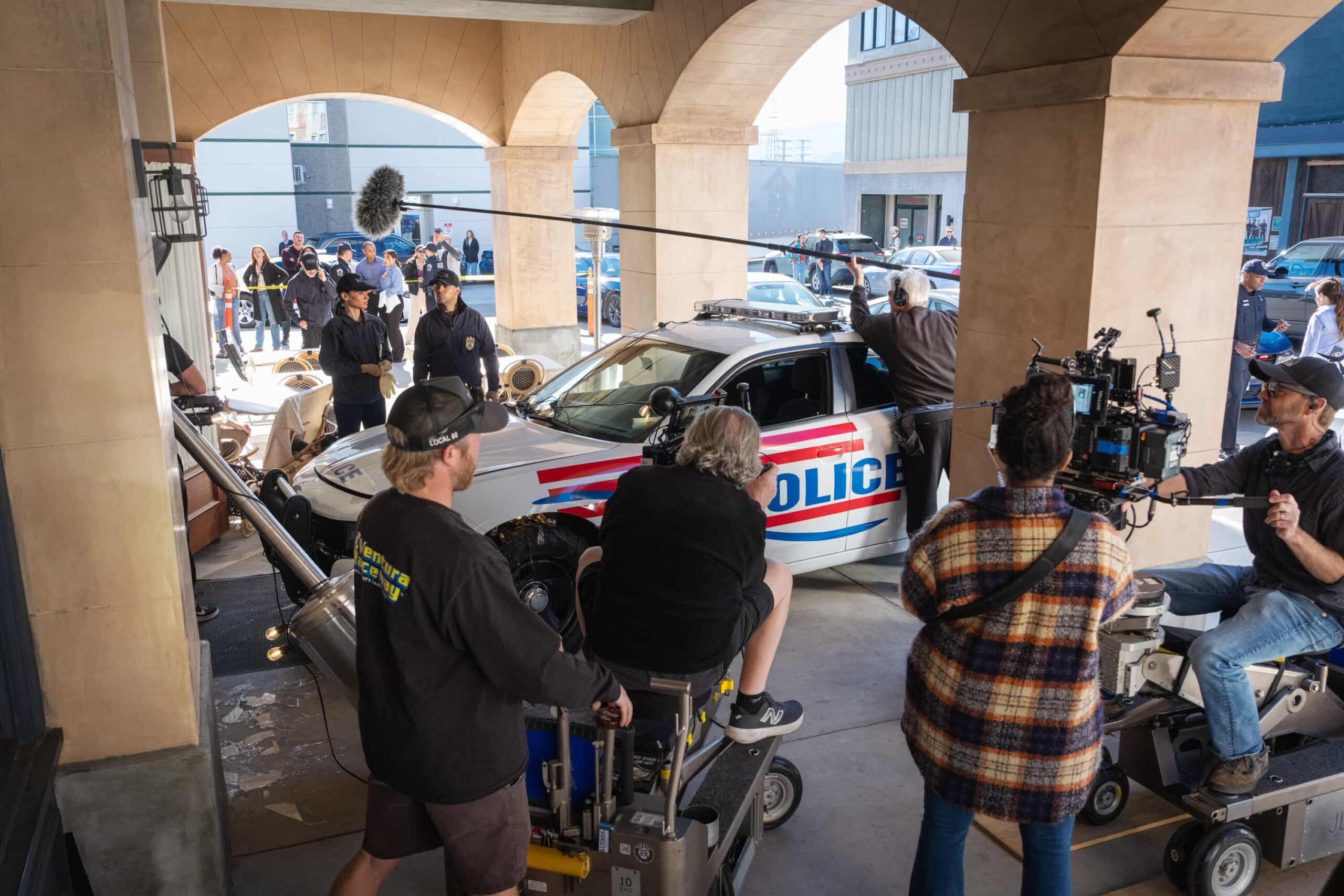 NCIS Season 23 Episode 14 BTS ( Behind The Scenes) —  “Fleeting” – Navy Week turns electric when a stolen squad car flips and reveals a sailor stabbed in the trunk. As D.C. spirals into chaos, the team chases a killer while carrying the weight of recent events, on the CBS Original series NCIS, Tuesday, March 31 (8:00-9:00 PM, ET/PT) on the CBS Television Network    Pictured (L-R): Sean Murray as Timothy McGee, Gary Cole as Alden Parker, Wilmer Valderrama as Nick Torres, Katrina Law as Jessica Knight, Rocky Carroll as Leon Vance, Brian Dietzen as Jimmy Palmer and Diona Reasonover as Kasie Hines.        Photo: Robert Voets/CBS ©20256CBS Broadcasting, Inc. All Rights Reserved.