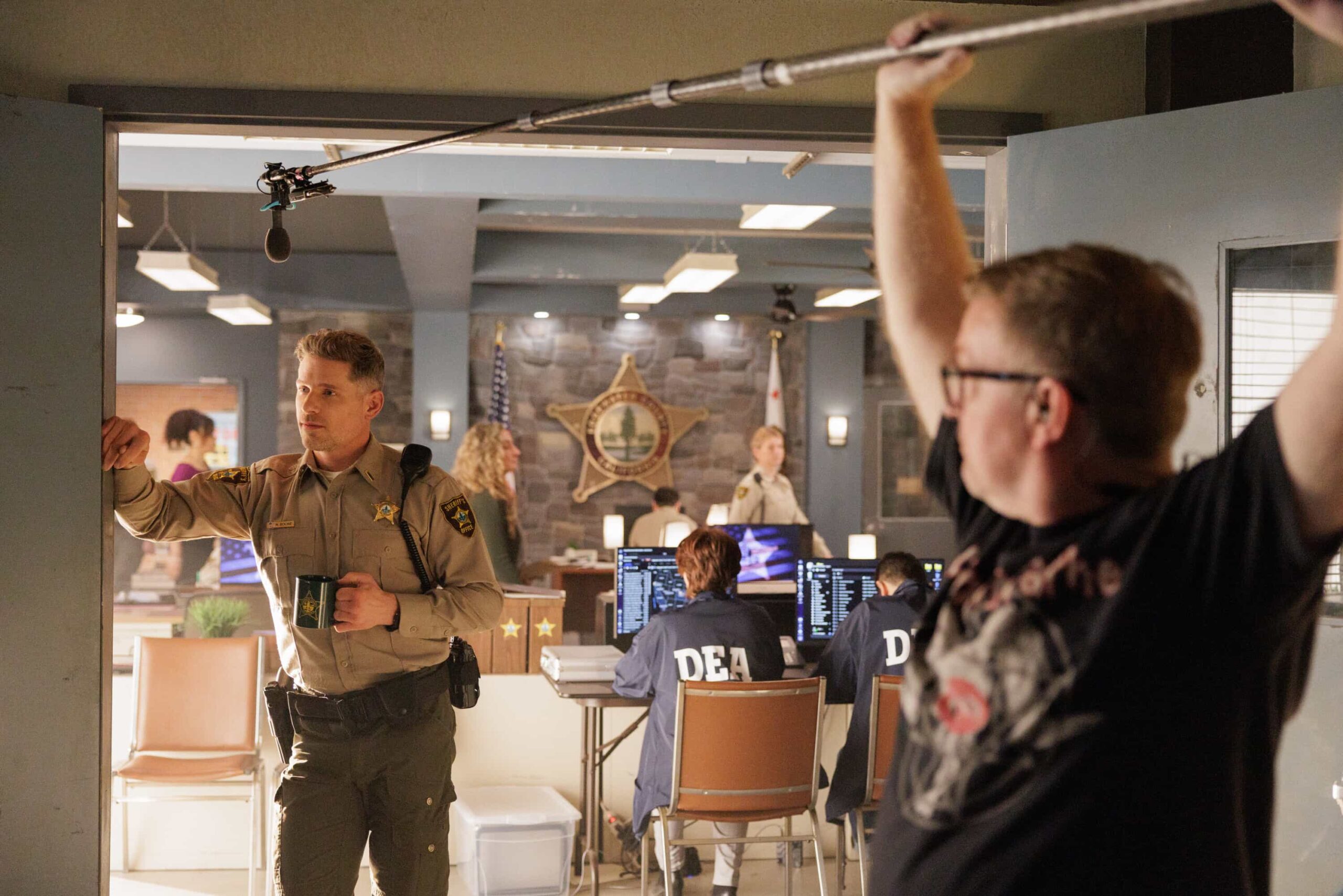 BTS “Compromised” – Sheriff Mickey Fox aids a federal investigation into a high-stakes case involving alleged interstate crime and a web of local land deals. GRAMMY® Award-winner Maren Morris guest stars as Hazel, Skye’s sponsor, on SHERIFF COUNTRY, Friday, May 15 (8:00-9:00 PM, ET/PT) on the CBS Television Network, and streaming on Paramount+ (live and on-demand for Paramount+ Premium plan subscribers, or on-demand for Paramount+.   Pictured: Matt Lauria and Boom Operator Sean Armstrong. Photo: Darren Goldstein/CBS ©2026 CBS Broadcasting, Inc. All Rights Reserved.