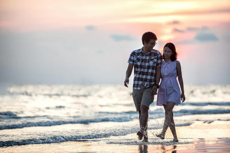 Couple Holding Hands On The Beach