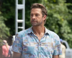 Scott Speedman as R.J. Decker stands outdoors in a blue patterned shirt in Season 2 Episode 4, “The Angler.”