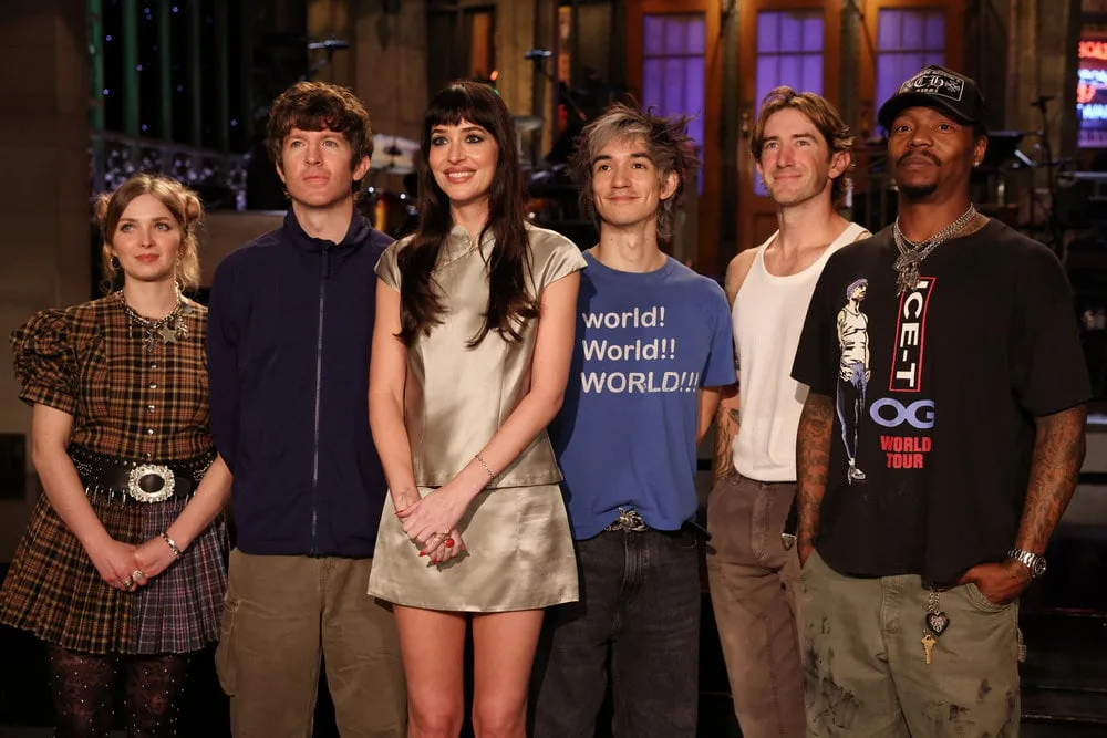 SATURDAY NIGHT LIVE -- Episode 1906 -- Pictured: Host Dakota Johnson (center) with musical guest Turnstile during Promos on Thursday, October 1, 2026 -- (Photo by: Rosalind OConnor/NBC)