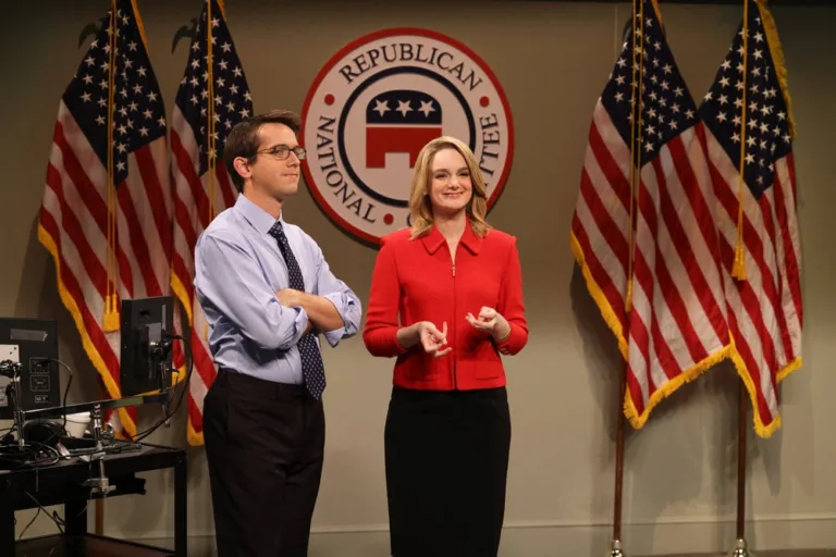 SATURDAY NIGHT LIVE -- Episode 1906 -- Pictured: (l-r) Andrew Dismukes and Ashley Padilla as political aid during the "Midterm Ads Cold Open" on Saturday, October 3, 2026 -- (Photo by: Will Heath/NBC)