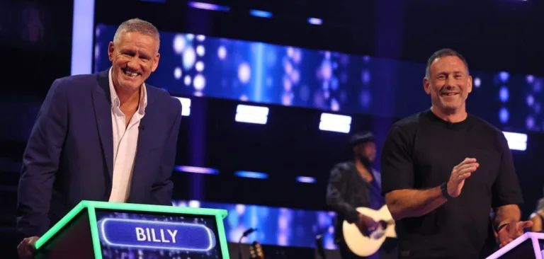 Billy Billingham and Jason Foxy Fox standing at their game show podiums competing against each other.