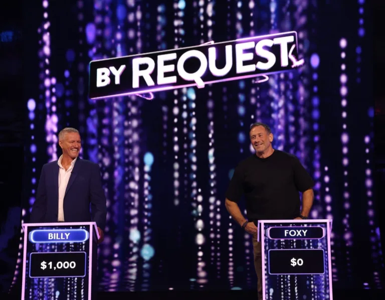 Billy Billingham and Jason Foxy Fox standing at their game show podiums competing against each other.