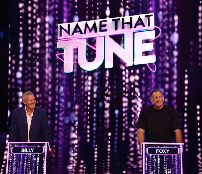 Billy Billingham and Jason Foxy Fox standing at their game show podiums competing against each other.