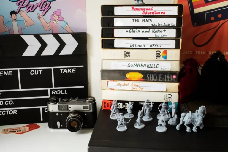 Stack of vintage VHS tapes next to clapperboard and miniatures